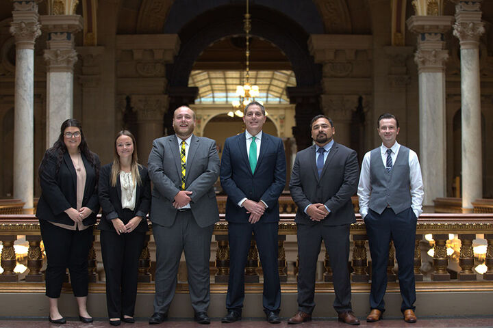 A group of law students stands in the lobby of a courthouse.